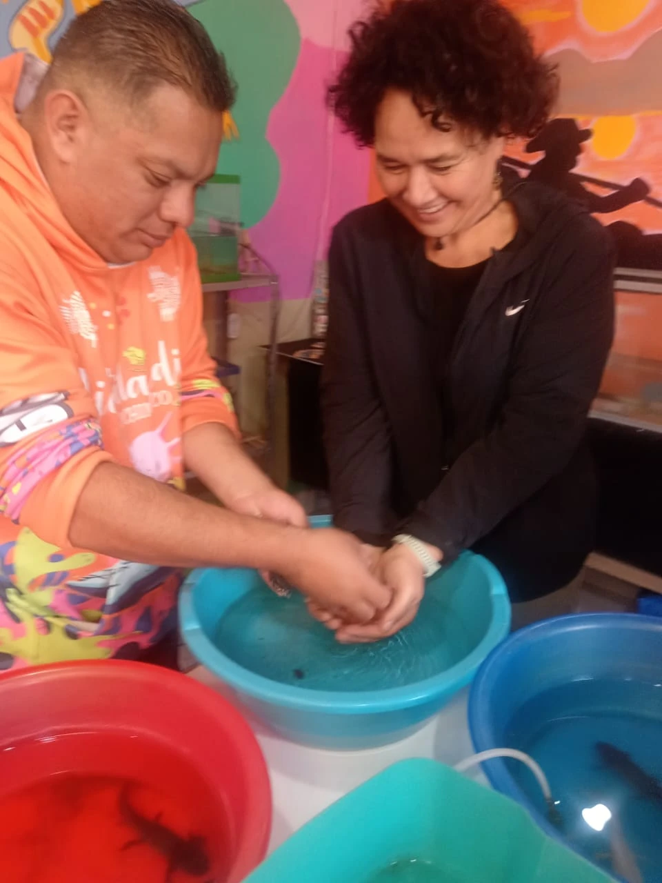 Manos mojadas para interactuar con los ajolotes bajo la guía del personal