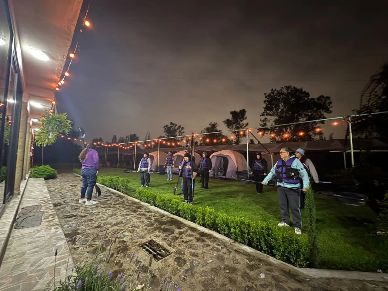 Vista del pasillo de tiendas y jardín por la noche