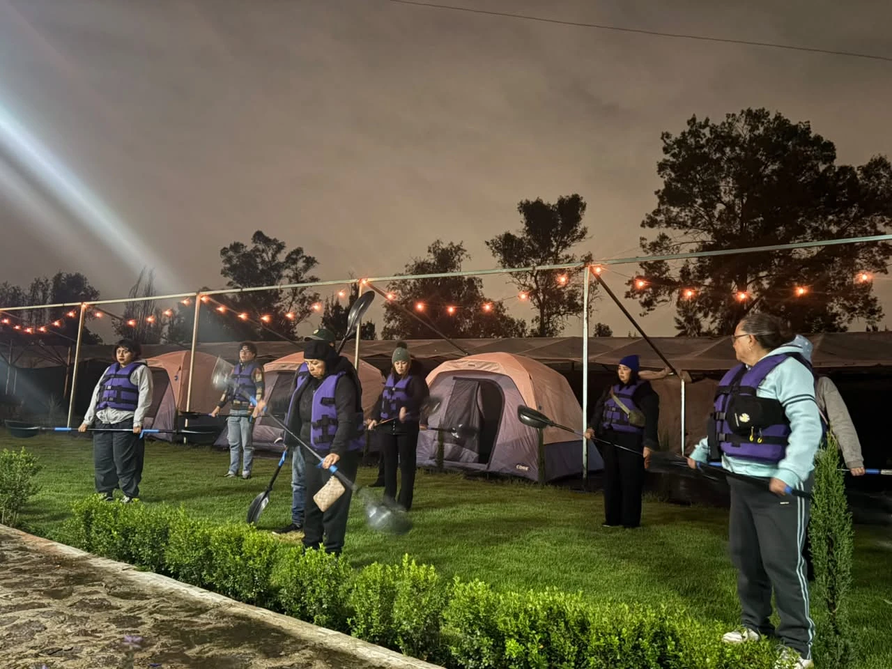 Carpas iluminadas con guirnaldas de luces en el jardín del camping